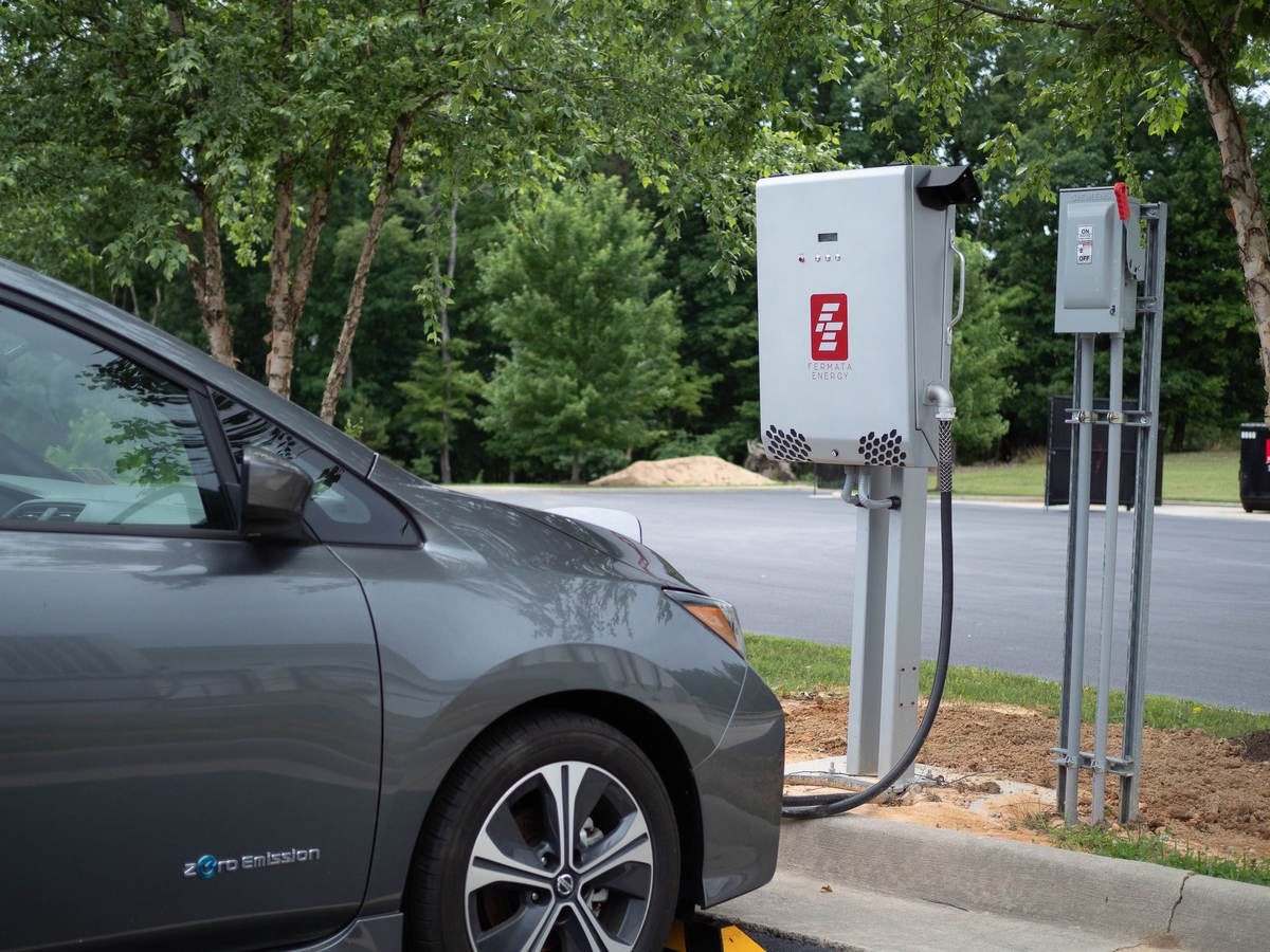 Image of silver electric vehicle and white bidirectional charger